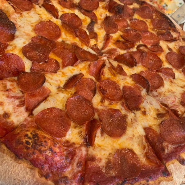 Close-up of a Homerun Pizza pepperoni pizza, with melted cheese and crispy pepperoni slices.